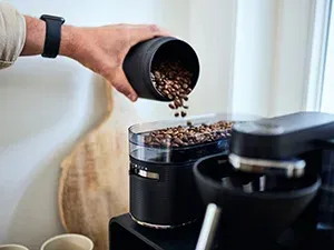 Frisch gemahlene Kaffeebohnen in einer Melitta EPOS® Filterkaffeemaschine mit Mahlwerk