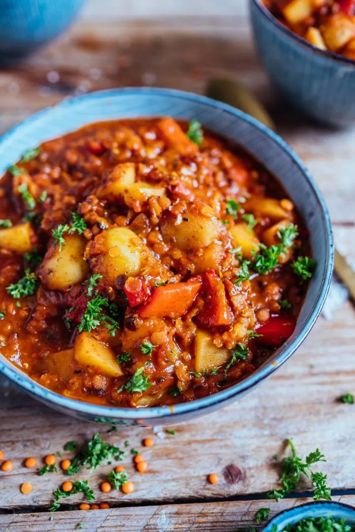 Frisch geschnittene rote Paprika, Zwiebeln und gehackter Knoblauch liegen bereit für die Zubereitung