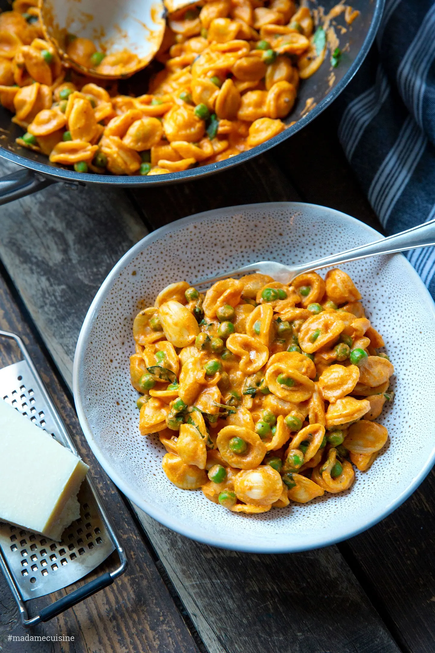 Frisch servierte Pasta mit Erbsen und Tomatensugo auf einem Esstisch