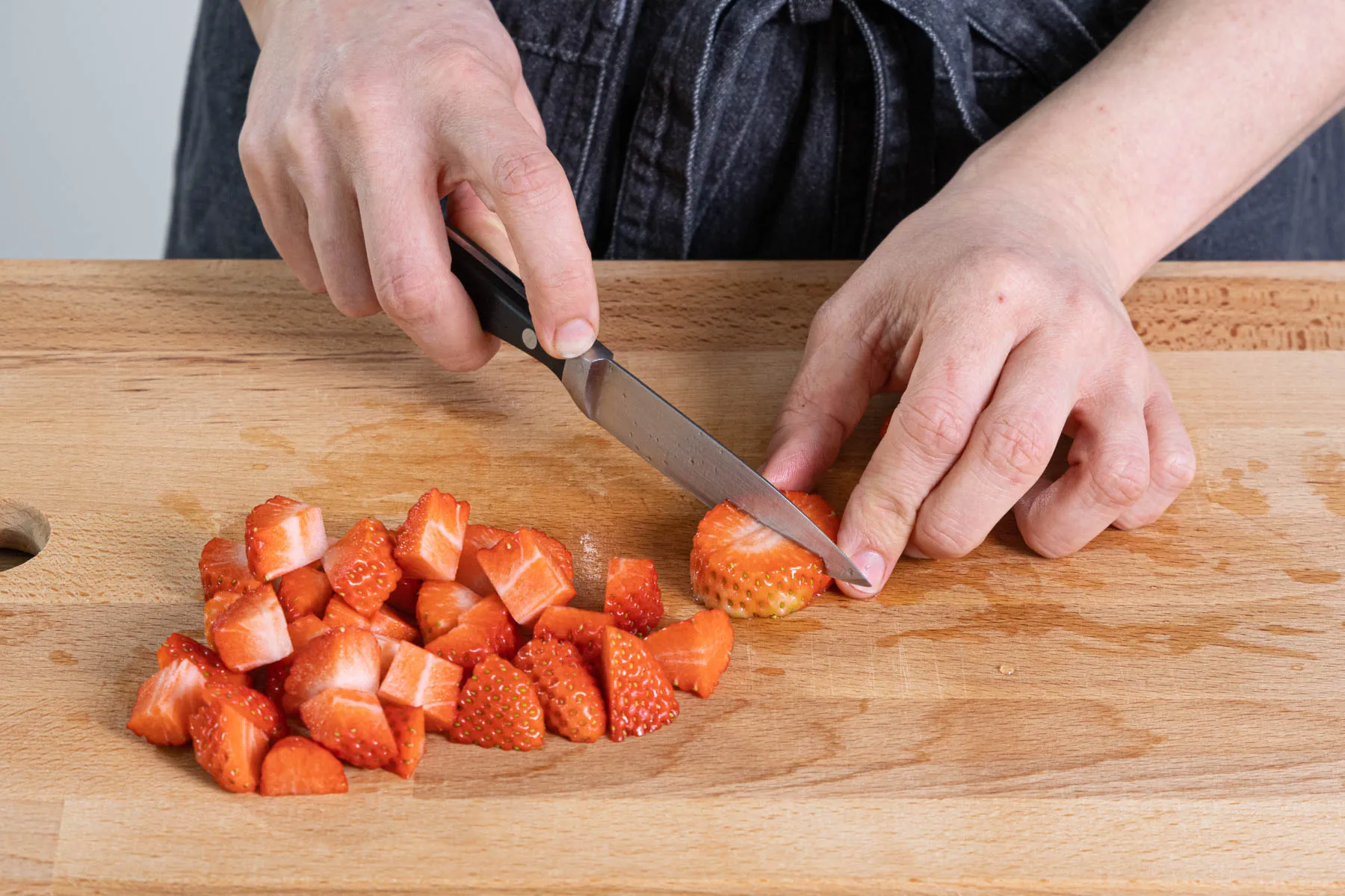 Frische Erdbeeren werden geputzt und in kleine Würfel geschnitten