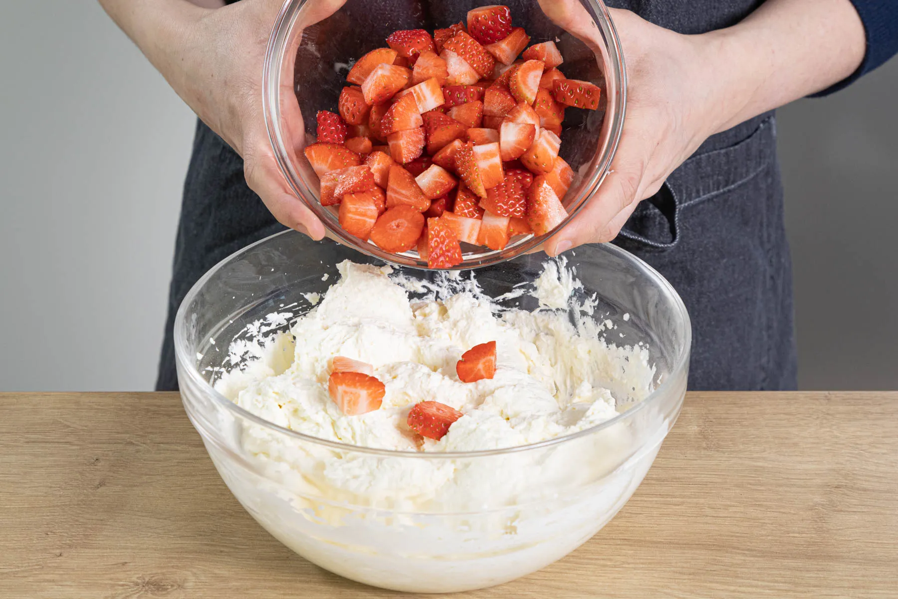 Frische Erdbeerwürfel werden behutsam unter die Frischkäsecreme gerührt