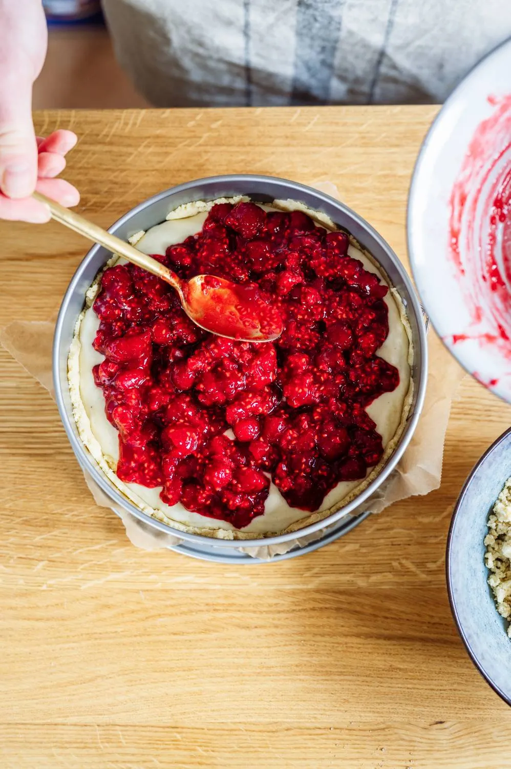 Frische Himbeeren werden vorsichtig mit Himbeermarmelade vermengt