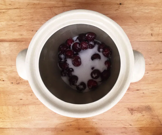 Frische Sommerfrüchte werden in einen Rumtopf gegeben