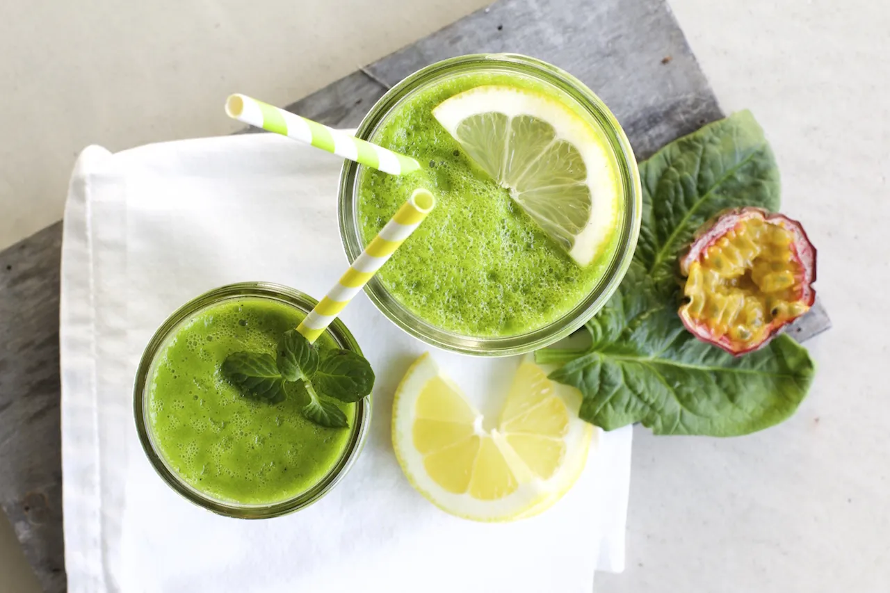 Frischer grüner Smoothie in einem Glas mit Zitronenscheibe