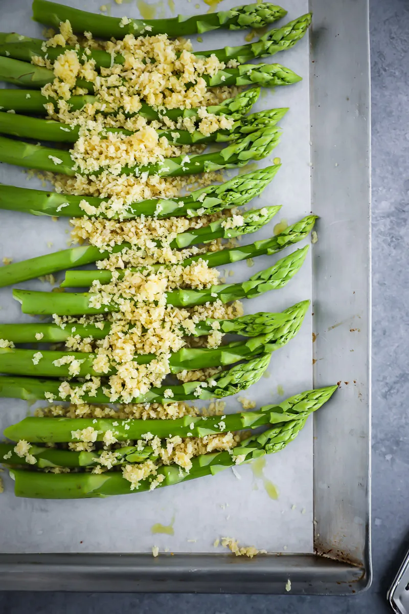 Frischer grüner Spargel auf einem Backblech, bereit für die Zubereitung