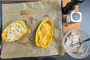 Fruchtfleisch vom Spaghettikürbis lösen und mit der Füllung und den Gewürzen vermengen