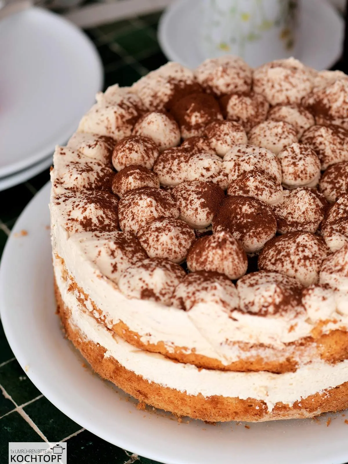 Ganze Tiramisu-Torte auf weissem Teller