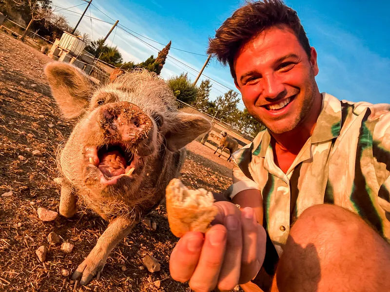Gastgeber Kiko mit einem Schwein auf dem Kiks Farmhouse Mallorca