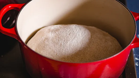 Gebackenes Brot in einem heißen Gusseisentopf im Backofen