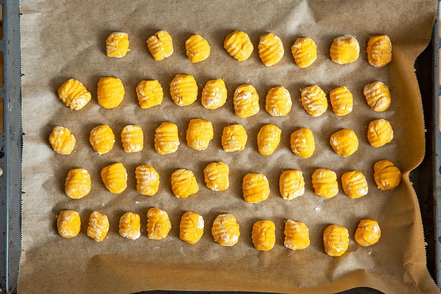 Geformte Kürbis-Gnocchi liegen auf einem Backblech zum Trocknen