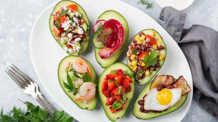 Gefüllte Avocado mit einer Vielzahl von farbenfrohen Belägen für eine schnelle Mahlzeit