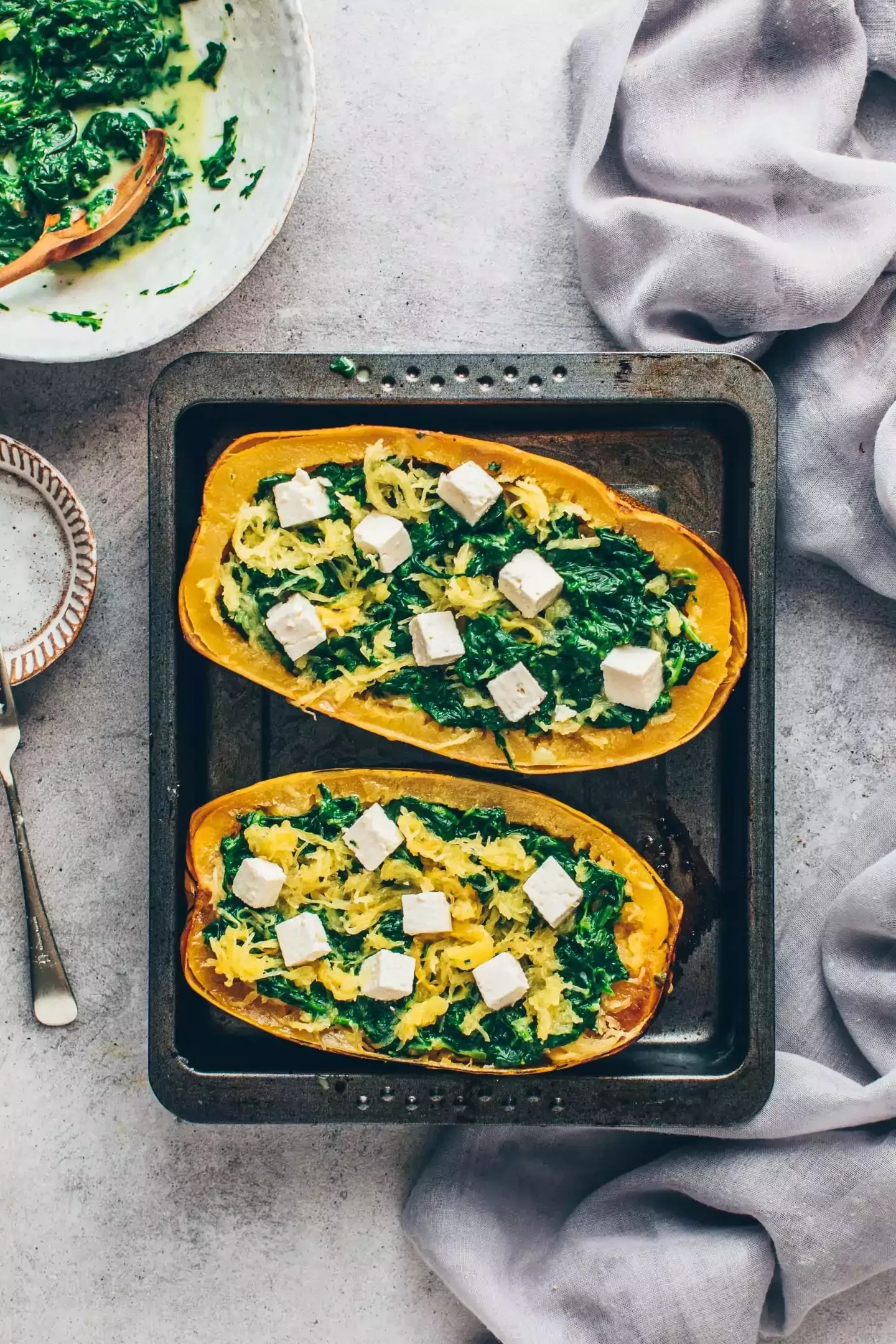 Gefüllte Spaghetti-Kürbis-Boote mit Spinatcreme und veganem Feta vor dem Backen
