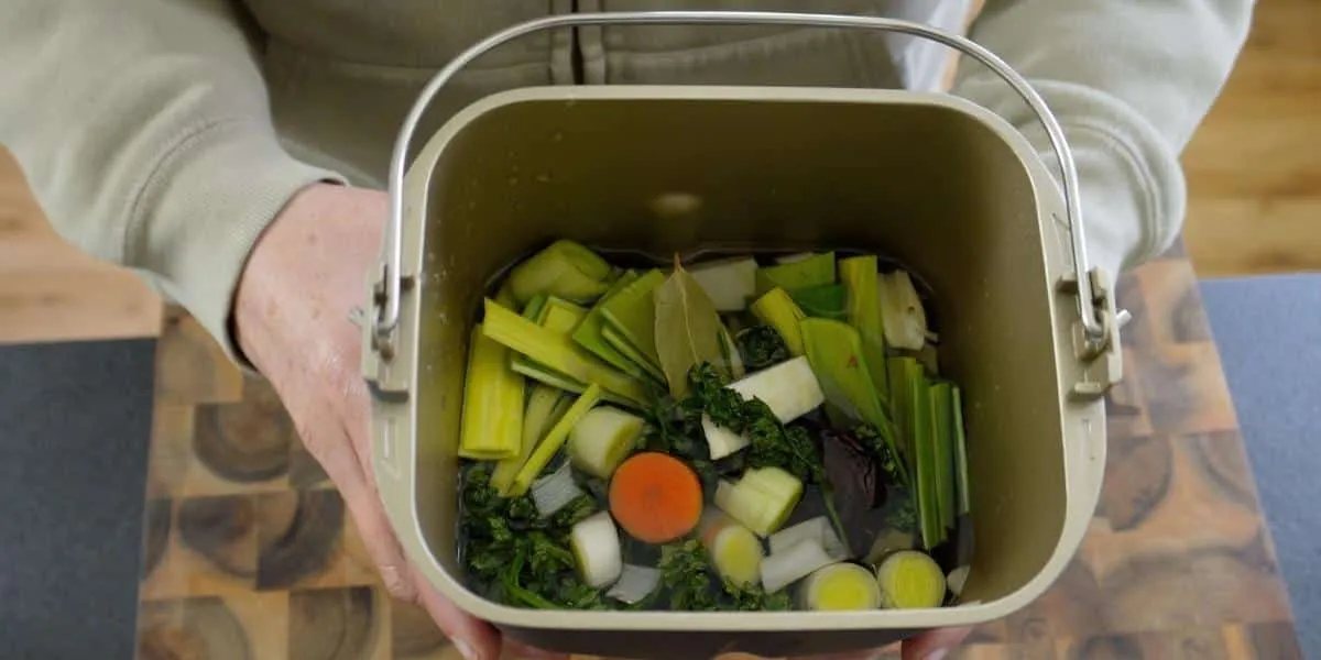 Gemüsebrühe aus dem Brotbackautomaten, Gemüse in der Backform, gehalten von zwei Händen