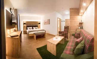 Gemütliches Hotelzimmer im Wald-Flair mit Holzdekor und Sitzecke, ideal für Entspannung