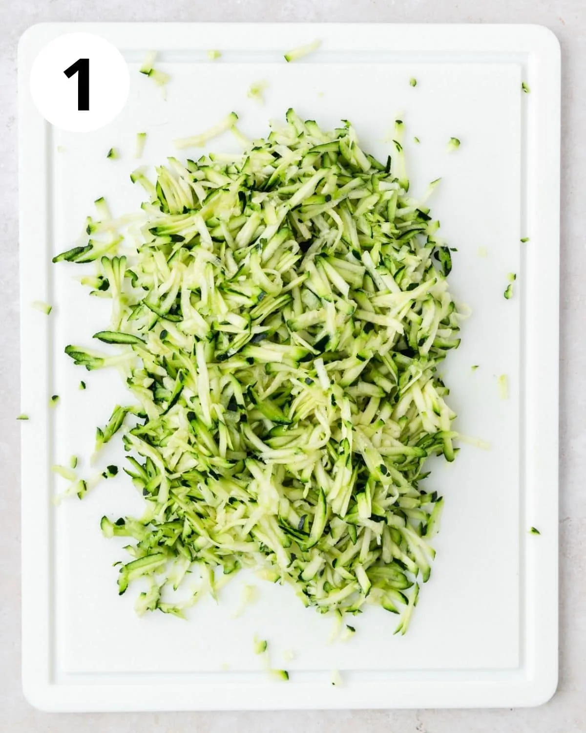 Geriebene Zucchini auf einem Schneidebrett