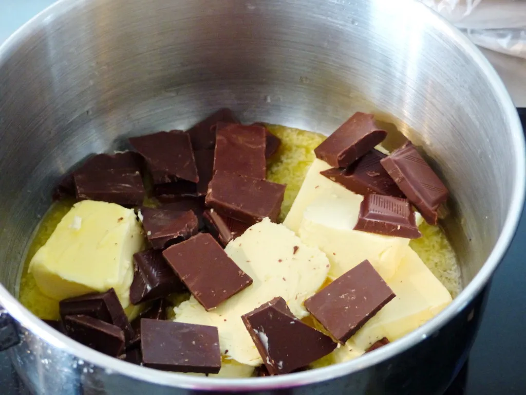 Geschmolzene dunkle Schokolade und Butter in einem Topf, bereit zur Weiterverarbeitung im Sven Epiney Kuchen
