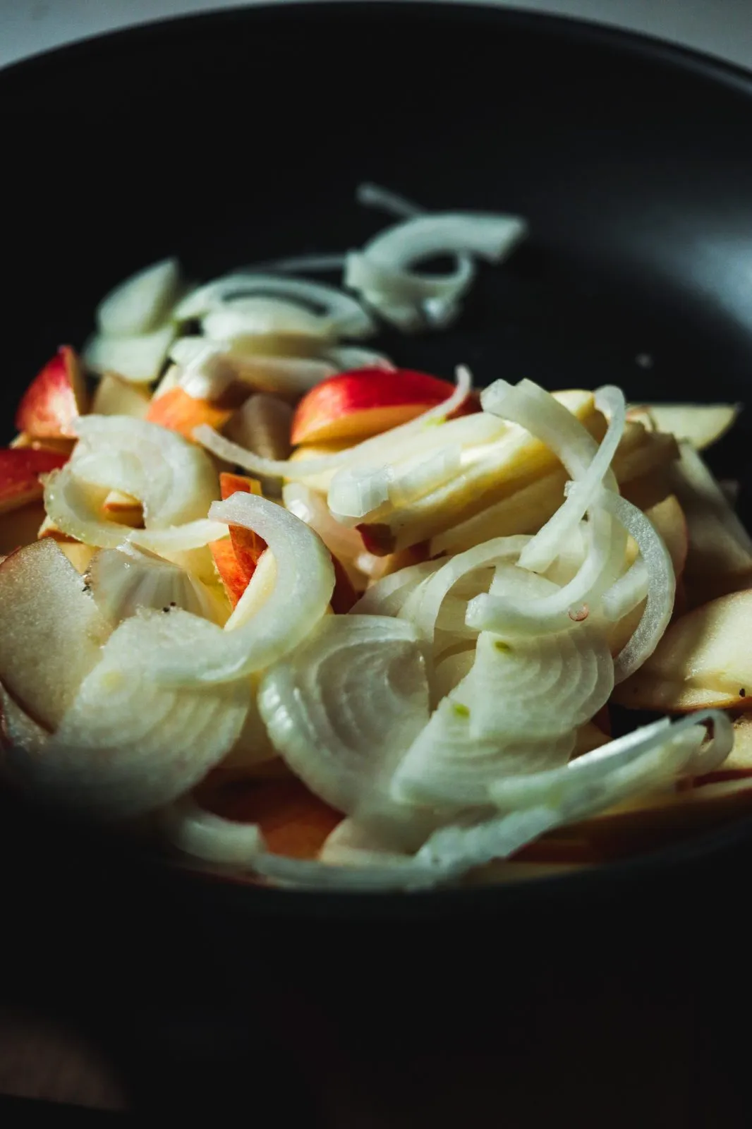 Geschnittene Äpfel und Zwiebeln in der Pfanne