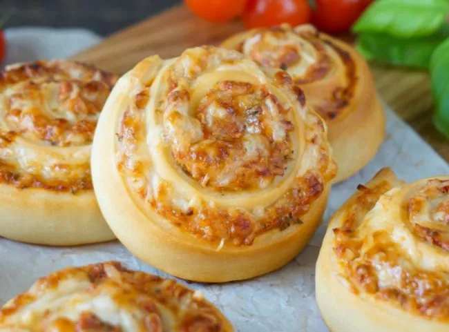 Goldbraune Pizzaschnecken auf einem Backblech, bereit zum Servieren