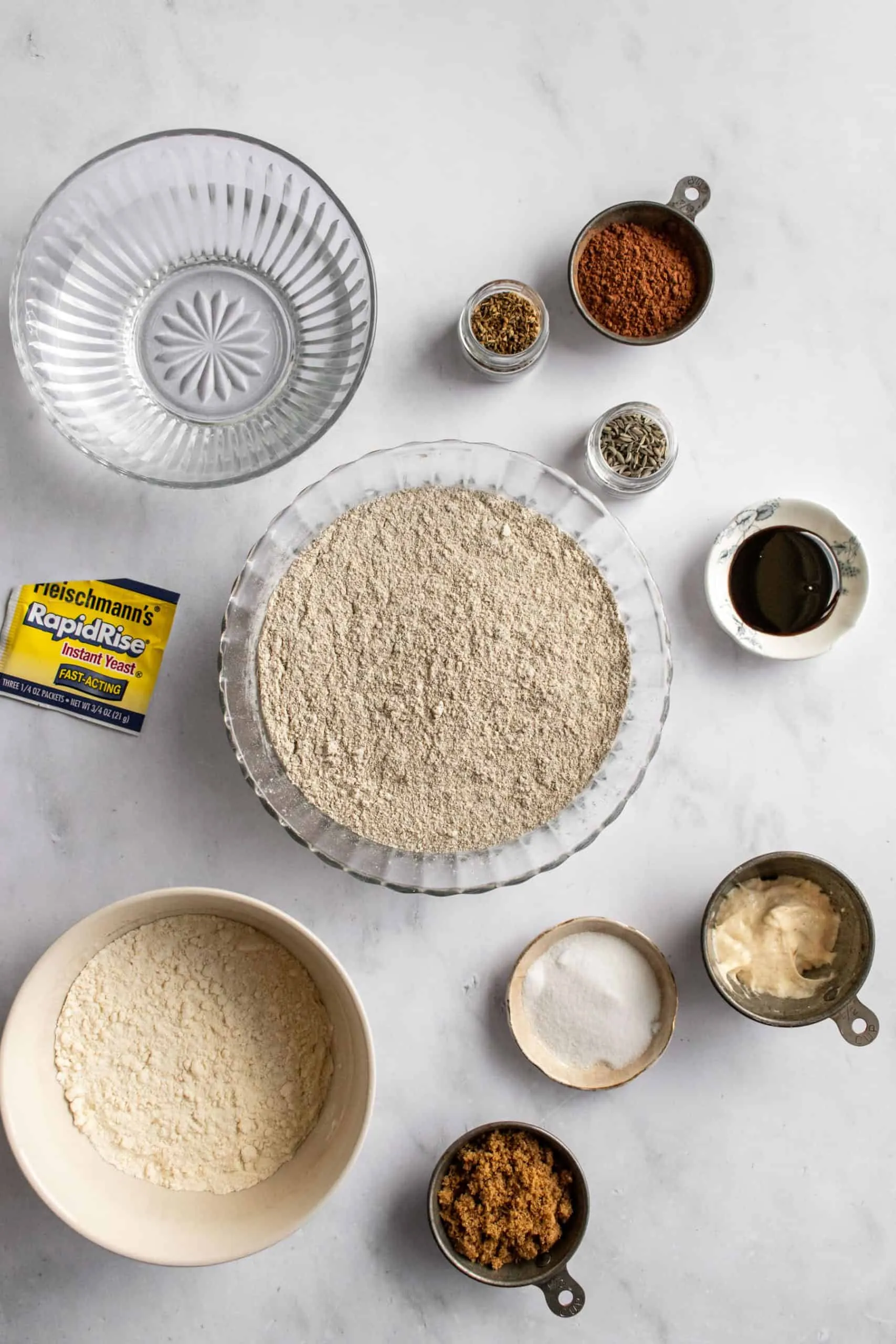 Große Schüssel mit Roggenmehl und anderen Zutaten auf Marmortisch.