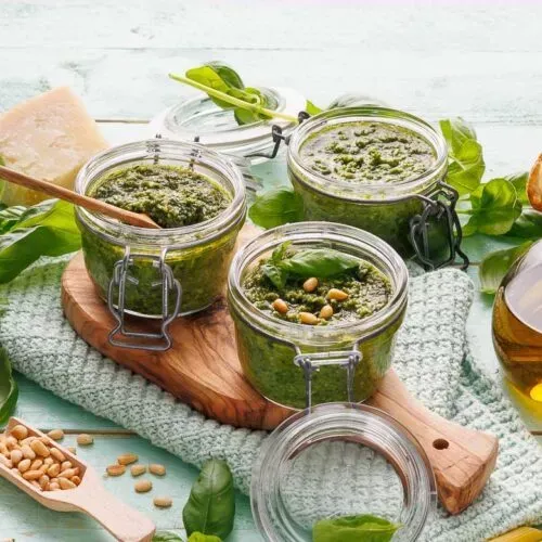 Grünes Pesto mit Basilikum und Pinienkernen in einem kleinen Glas von oben