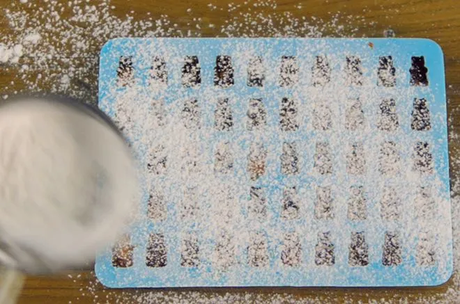 Gummibärchen in der Silikonform im Kühlschrank mit Stärke bedeckt