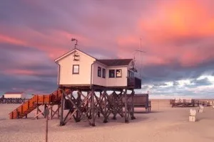 Häuser auf Pfählen am breiten Sandstrand von St. Peter-Ording an der Nordsee