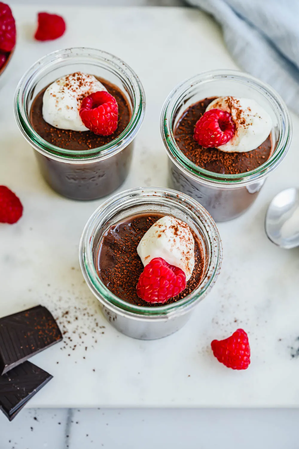 Hausgemachter Schokoladenpudding mit Kakao und großzügiger Sahnehaube, bestreut mit Raspeln