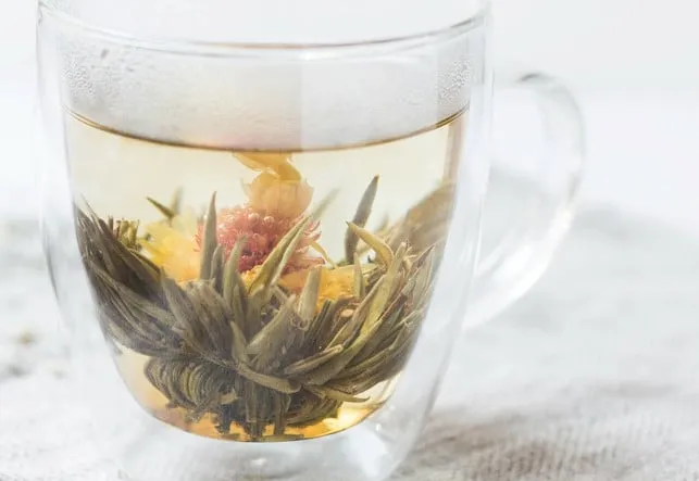 Heiße Flüssigkeiten und Wärmflasche als Hausmittel gegen Gliederschmerzen bei Erkältung.