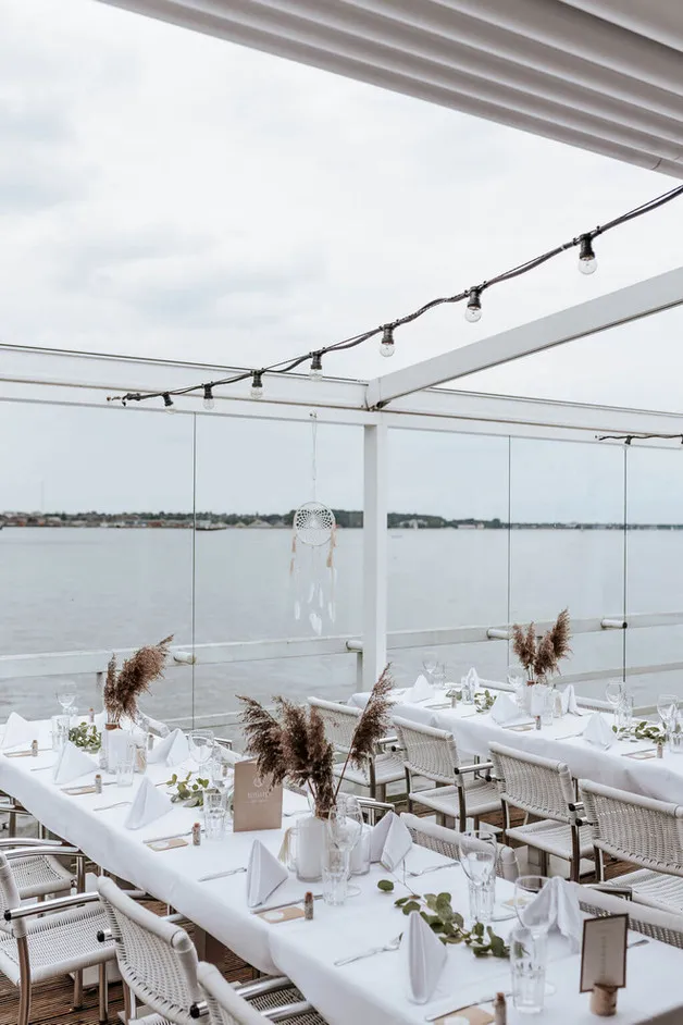 Holzterrasse der Seebar in Kiel direkt über dem Wasser mit Blick auf die Förde