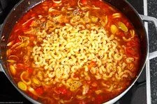 Hörnchennudeln und Brühe werden zur Hackfleischpfanne gegeben