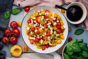 Im Ofen gebackener Lachs mit knuspriger Haut, serviert mit einer Auswahl an frischem Gemüse und Kräutern