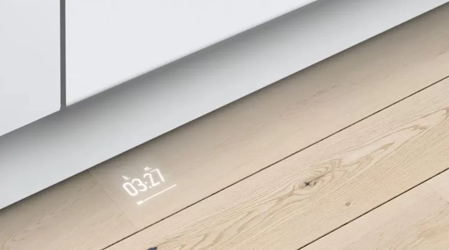 Innenansicht des oberen Korbs eines Bosch Geschirrspülers mit Besteckschublade und sauberem Besteck