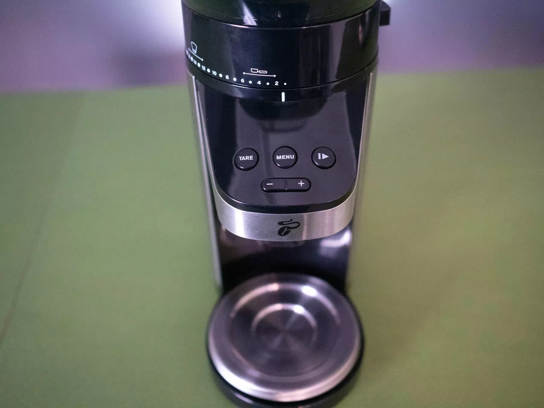 Integrierte Waage der Tchibo Kaffeemühle in der Stellfläche für das Mahlgut, mit einem Behälter darauf.