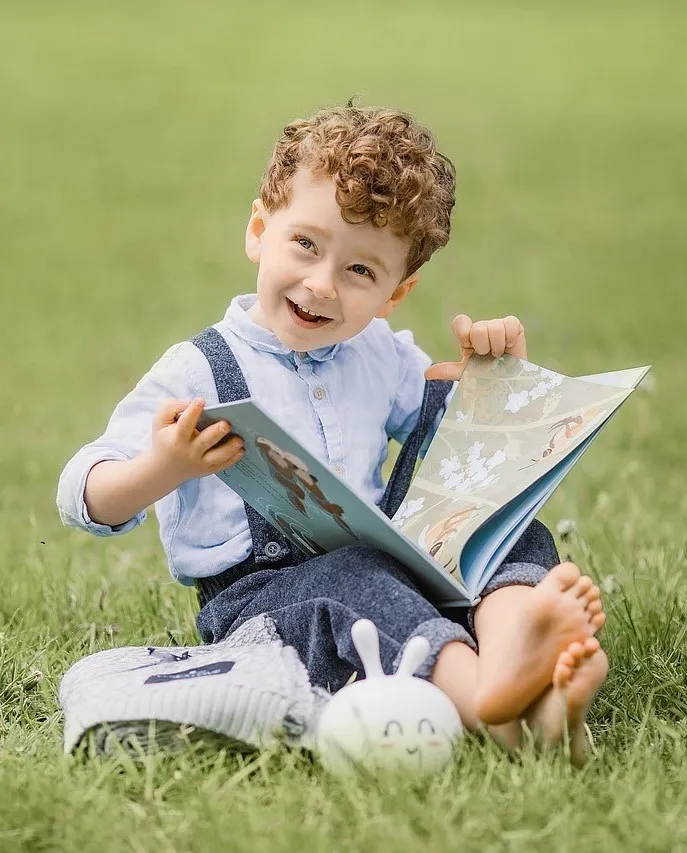 Jeannie, der Therapiehund, interagiert spielerisch mit einem Kind während einer Förderung