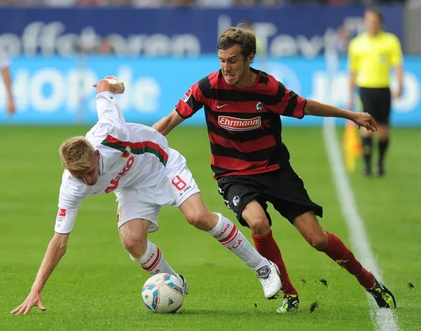 Julian Schuster vom SC Freiburg kämpft am Spielfeldrand um den Ball