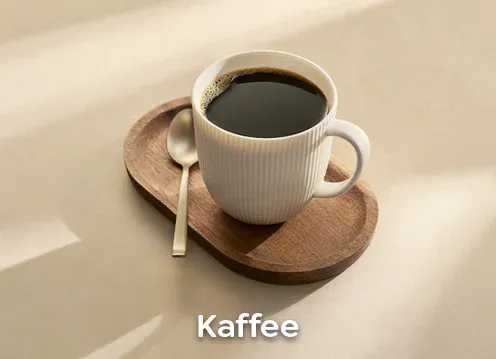 Kaffeebohnen in einer Melitta Verpackung und frisch gebrühter Kaffee in einer Tasse.