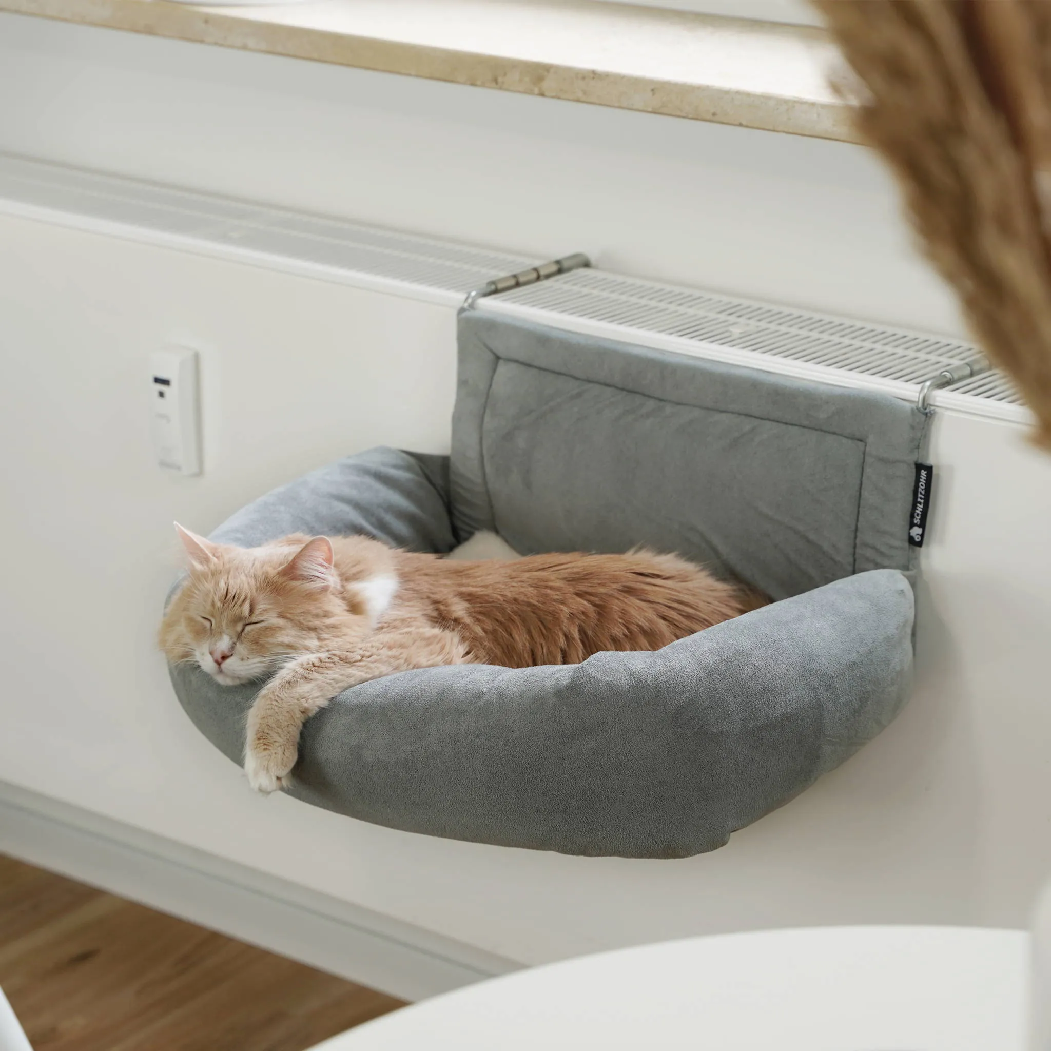 Katze genießt ihre gemütliche Heizungsliege Murphy am Heizkörper