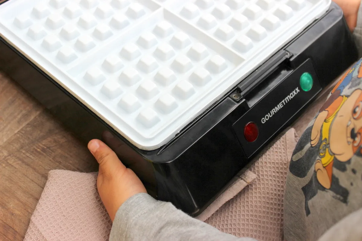 Kind probiert Waffel von einem Waffeleisen mit sicherer Keramikbeschichtung