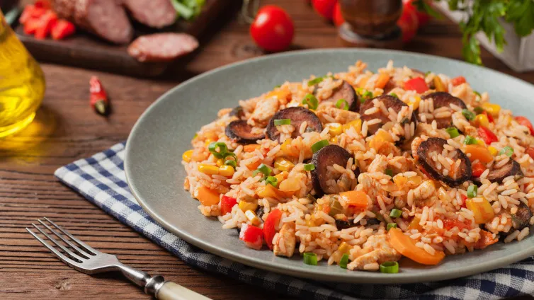 Kinderteller mit Reis, Brokkoli, Karotten und Hähnchenstreifen, freundlich angerichtet.