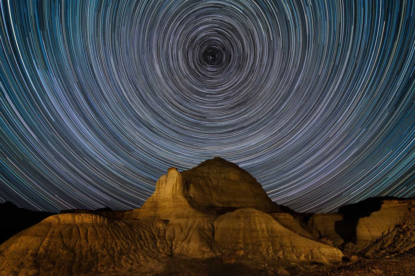 Konzentrische Sternspuren über einer Felsformation im Dinosaur Provincial Park