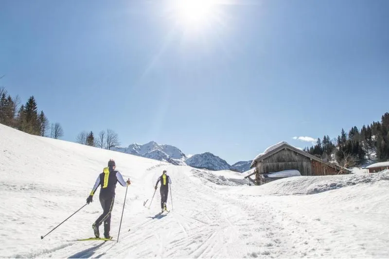 Langläufer in einer verschneiten österreichischen Landschaft, entdeckt mit Hofer Reisen