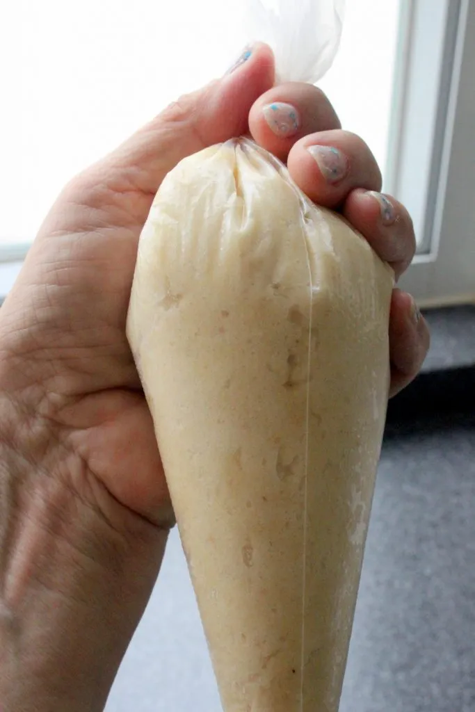 Mandelmasse wird auf Backpapier gespritzt