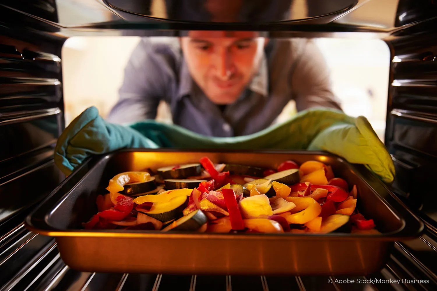Mann nimmt Gemüse aus dem Dampfgarer