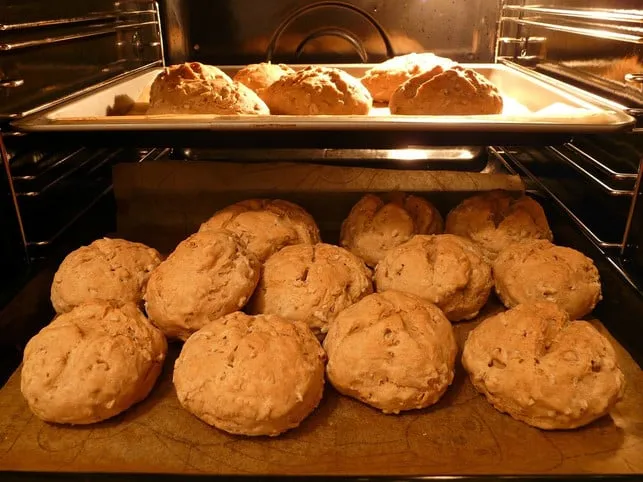 Mehrere Brötchen werden auf einem Backblech im Ofen aufgebacken