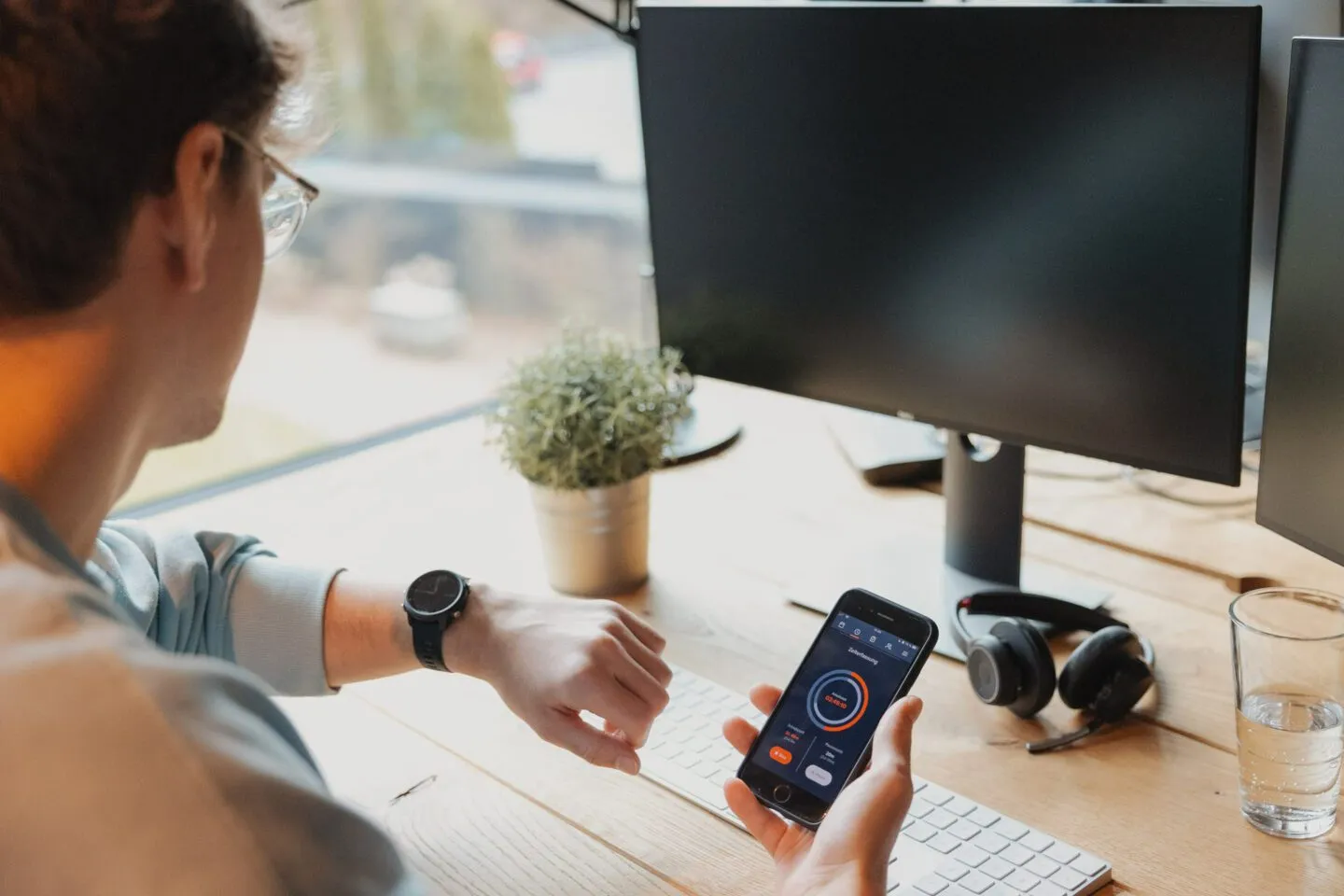 Mitarbeitender am Arbeitsplatz erfasst seine Arbeitszeit digital mit einer Anwendung