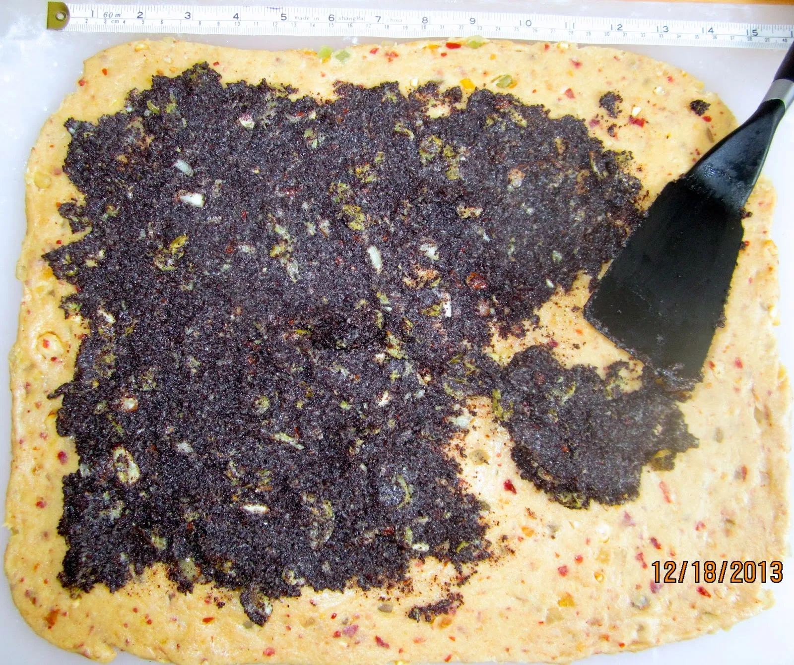 Mohnfüllung gleichmäßig auf dem Teig verteilen