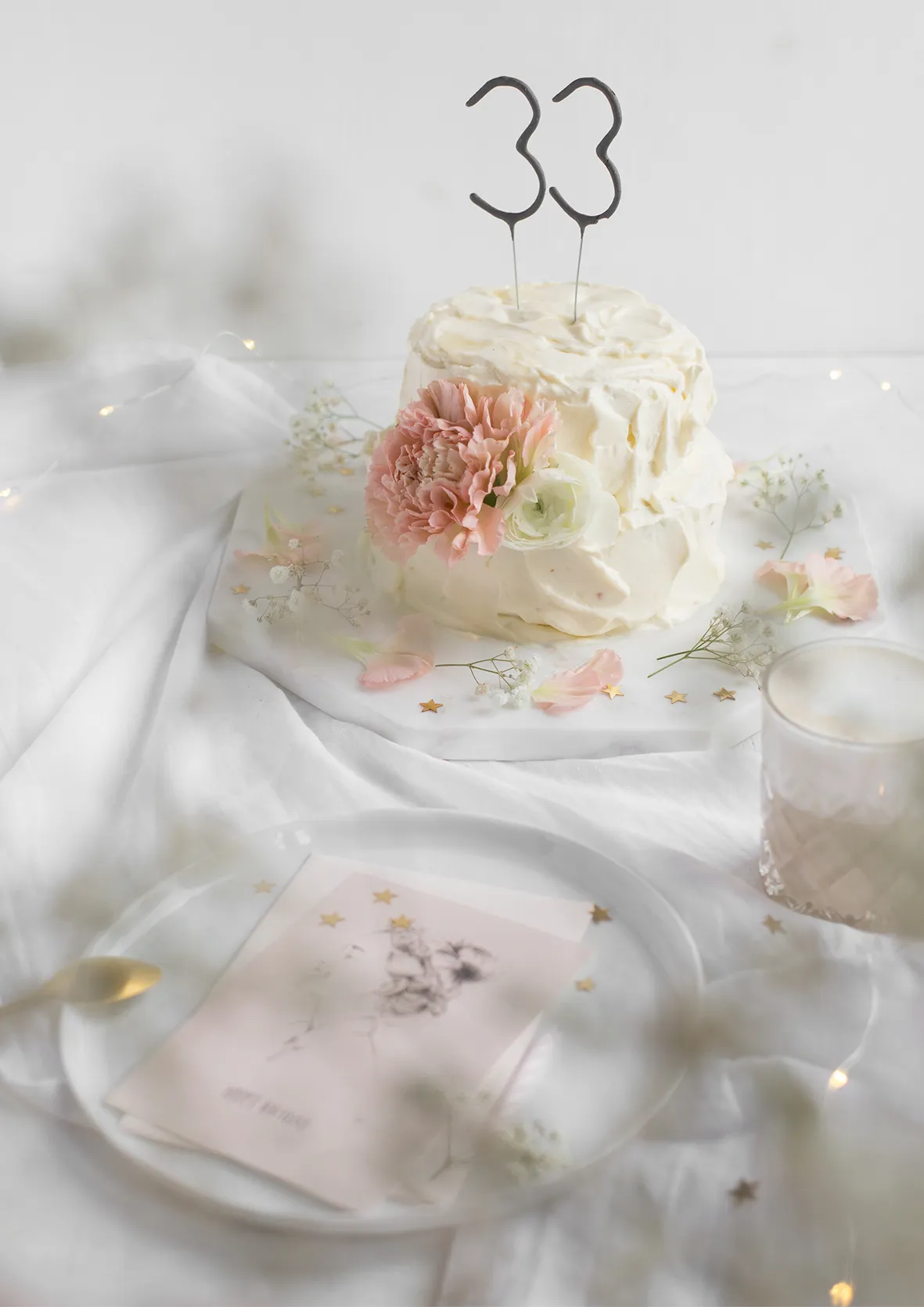 Nahaufnahme der liebevoll dekorierten Geburtstagstorte mit frischen Blumen