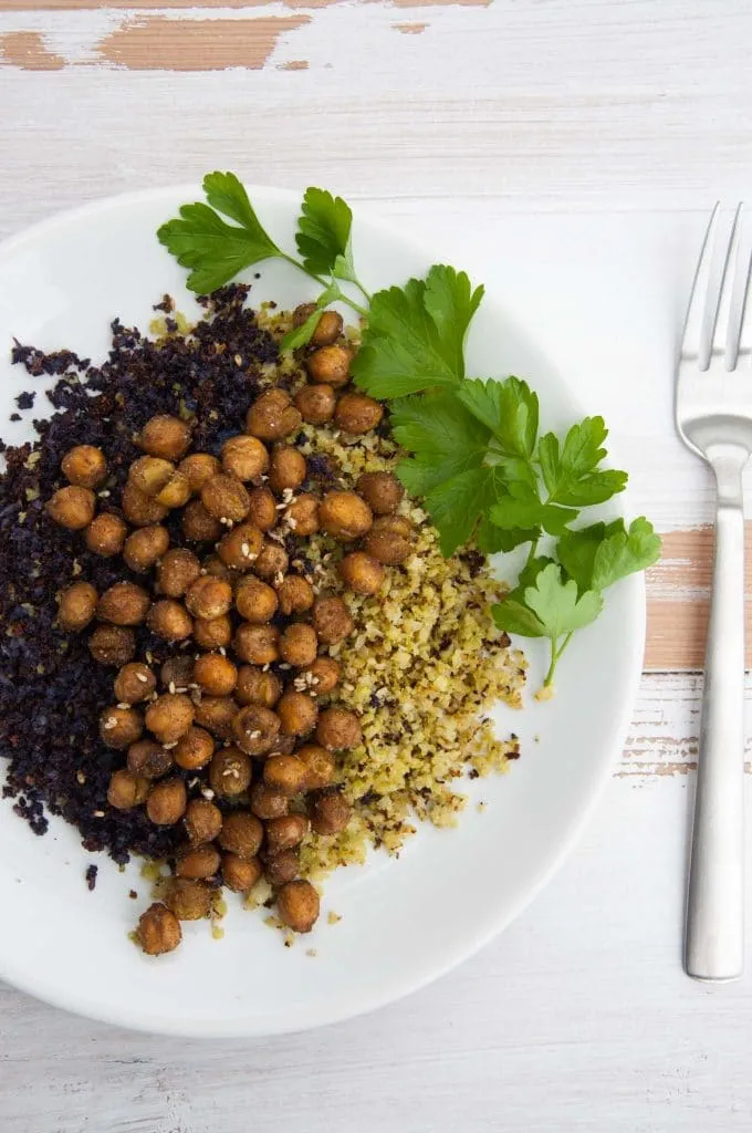 Nahaufnahme des fertig angerichteten Blumenkohlreises mit Kichererbsen und Petersilie