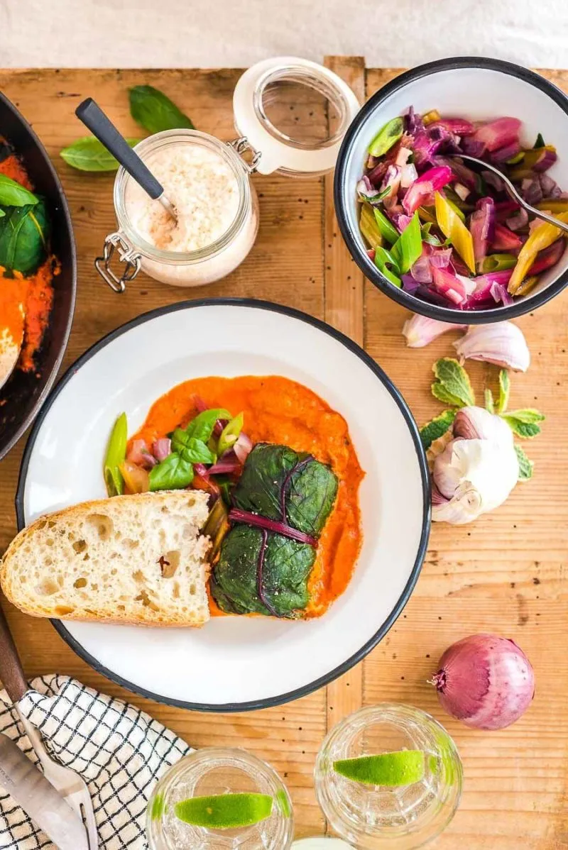 Nahaufnahme einer fertig gerollten vegetarischen Mangold-Roulade auf einem Schneidebrett