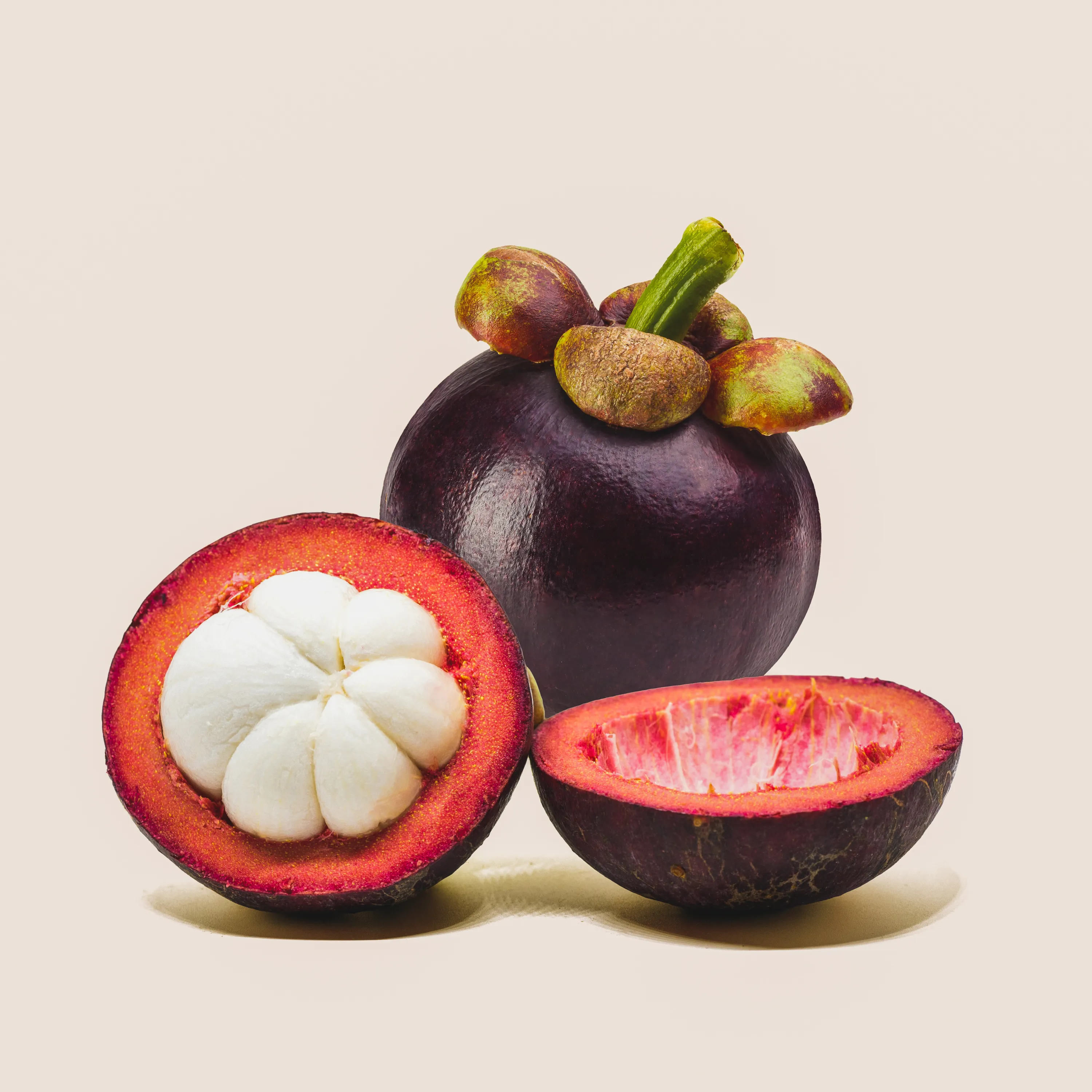 Nahaufnahme einer Mangosteen mit tiefvioletter Schale auf hellem Untergrund